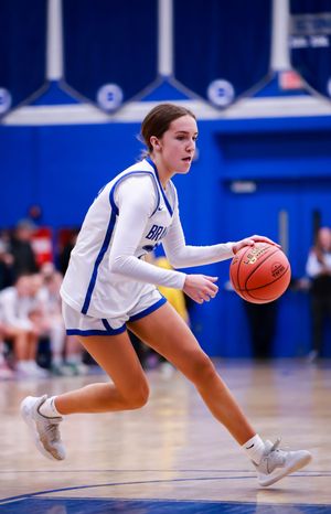 Basketball player performs crossover dribble move during intense game action.