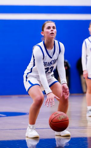 Basketball player in white uniform dribbles while getting into offensive position.
