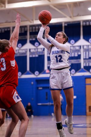 Players from Braintree and opposing team battle for possession during basketball game.