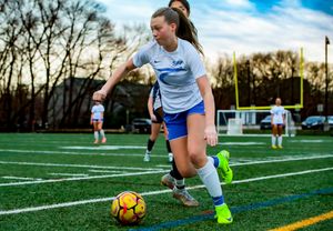 Soccer players practicing ball control drills on an artificial turf field.