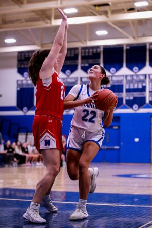 Low angle view of basketball players competing for ball during game action.