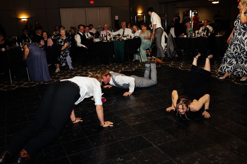 Guests dancing and playing on the floor at a wedding reception in a decorated banquet hall.