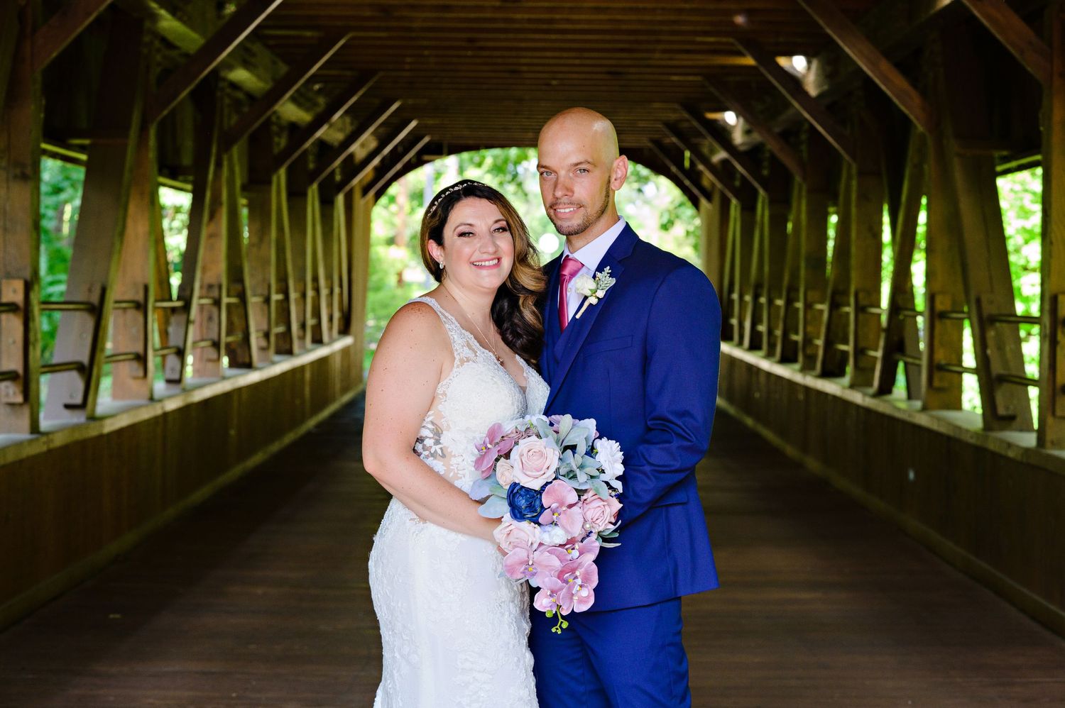 Bride and Groom posing on the covered bridge at Fortier Park in Olmsted Falls Ohio after their wedding ceremony at Columbia Ballroom.