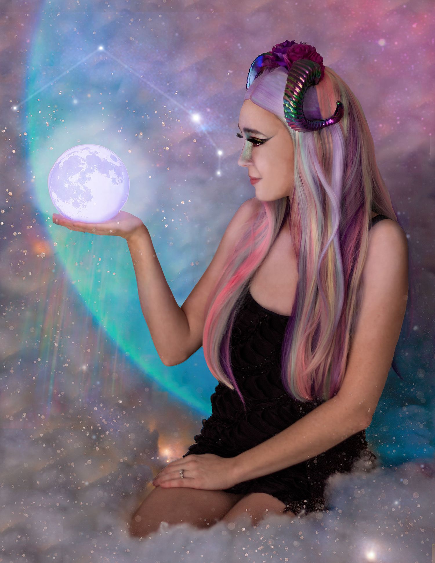 Fantasy woman with colorful hair holds glowing moon ball, wearing black dress and decorative horns against cosmic background.