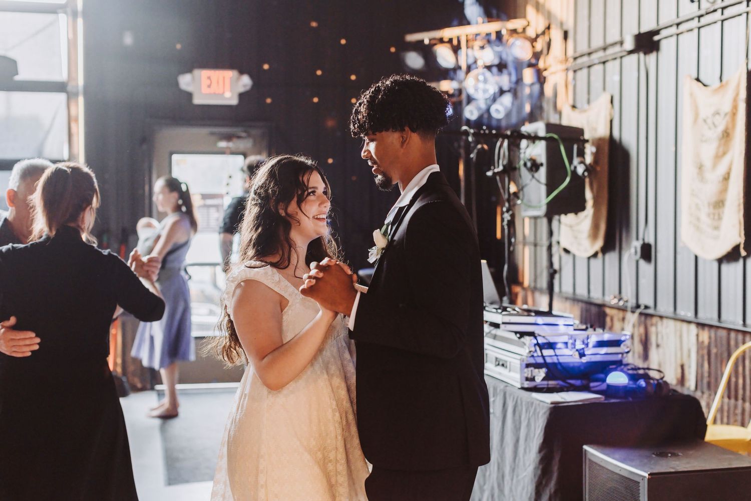 Bride and groom share their first dance at a romantic indoor wedding reception with warm ambient lighting.