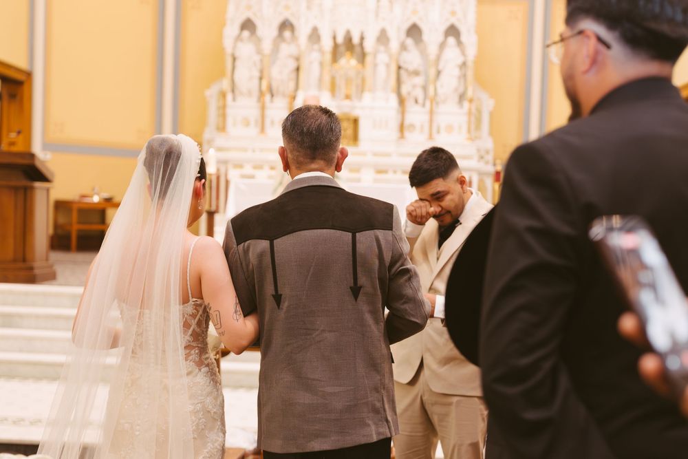 Bride and groom stand at the altar during a church wedding ceremony with ornate decor.