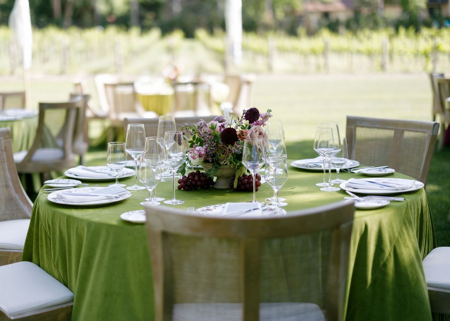 Wedding guests enjoy an elegant outdoor reception dinner under arches and palm trees at a luxury venue.