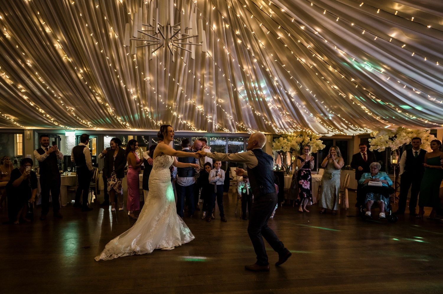 Bride and groom dancing beneath the illuminated reception ceiling at Killeavy Castle.