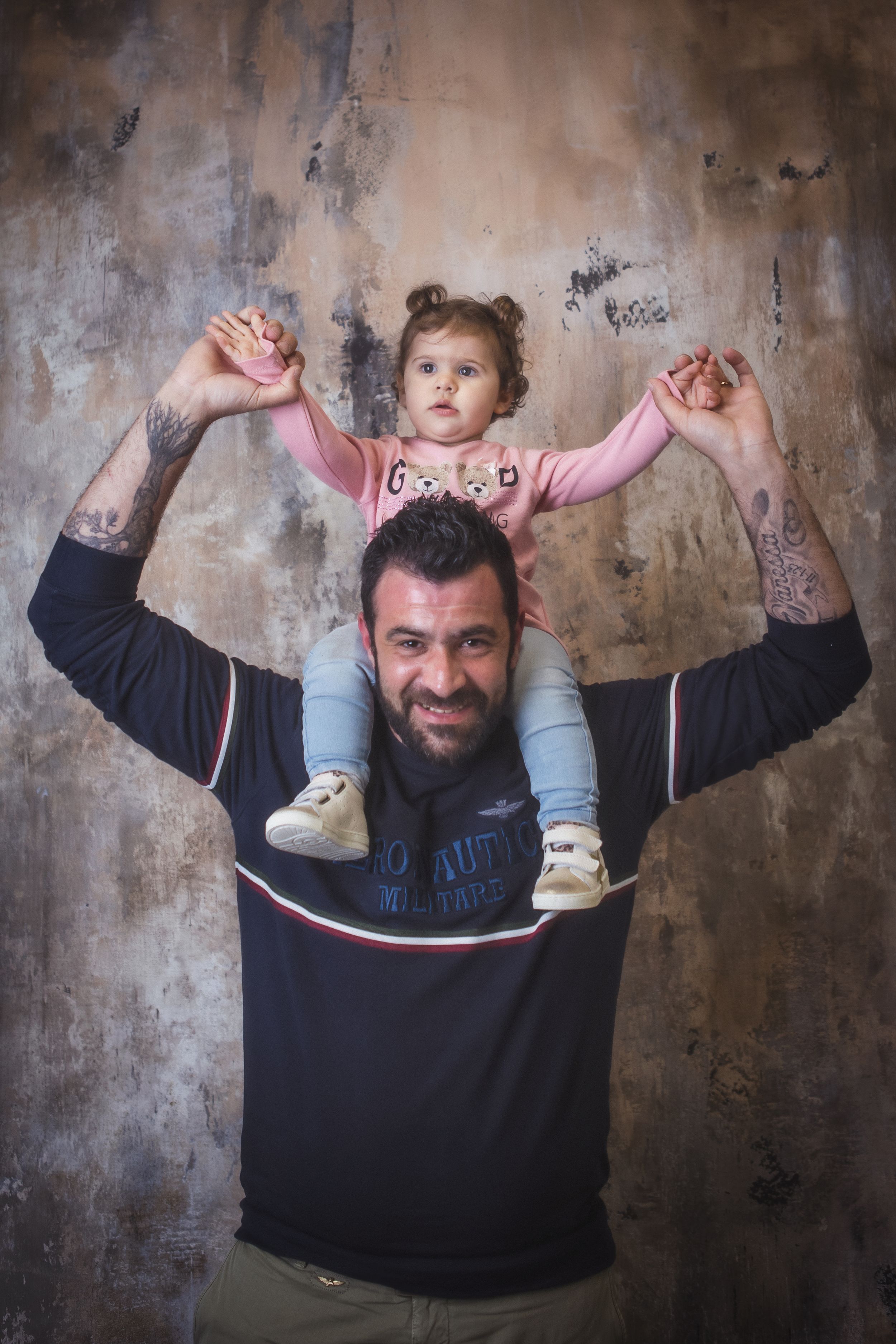 Papà con bambina sulle spalle durante un ritratto di famiglia