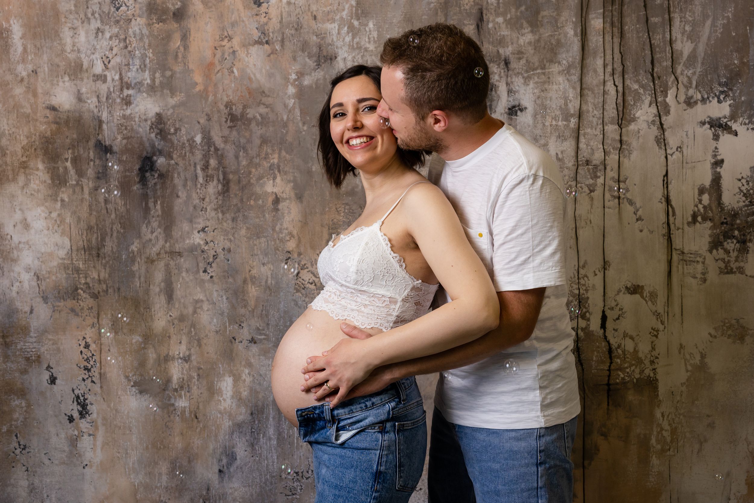 Coppia abbracciata durante un ritratto fotografico premaman