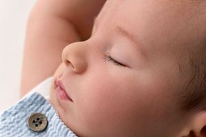Close-up portrait of a peaceful sleeping newborn baby in soft natural light.