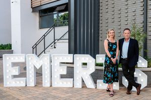 Guests posing beside Emeris signage at the Sandton Campus.