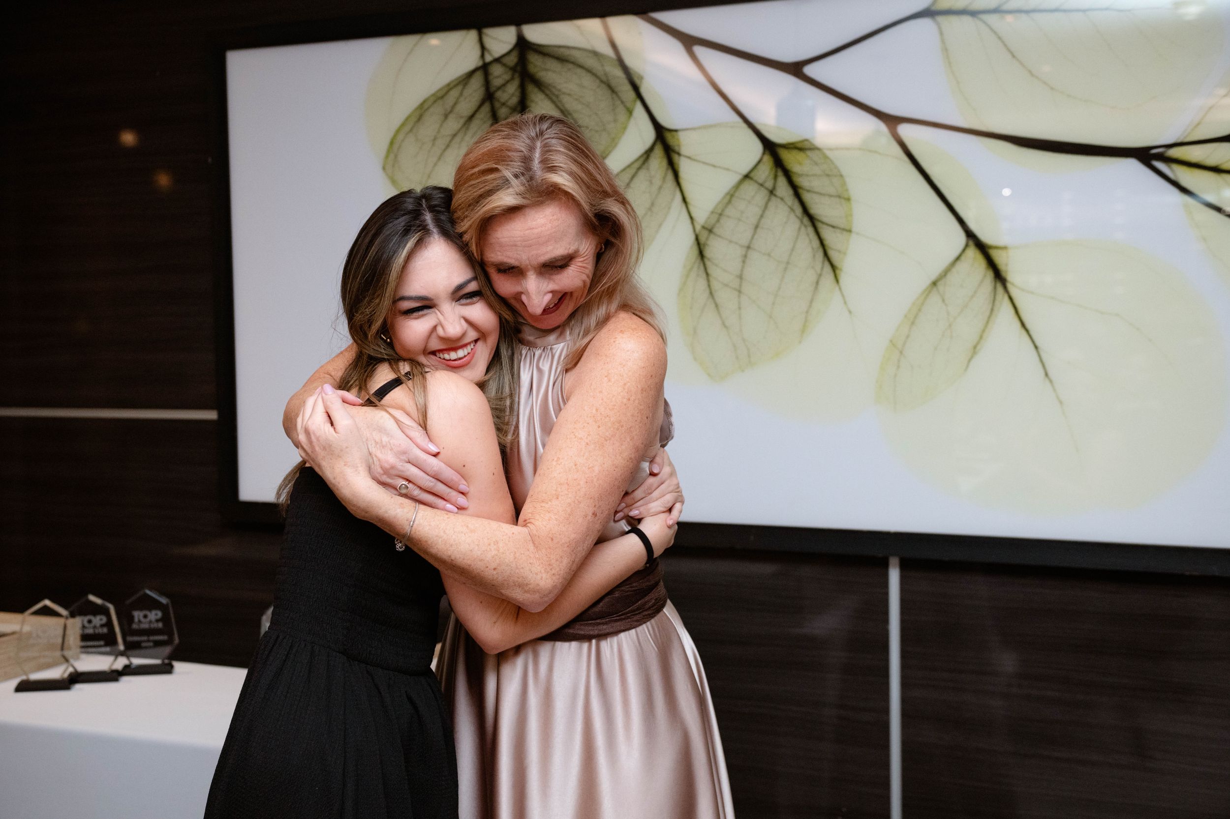 Warm celebratory moment between guests at the Emeris Top Achiever Awards ceremony.