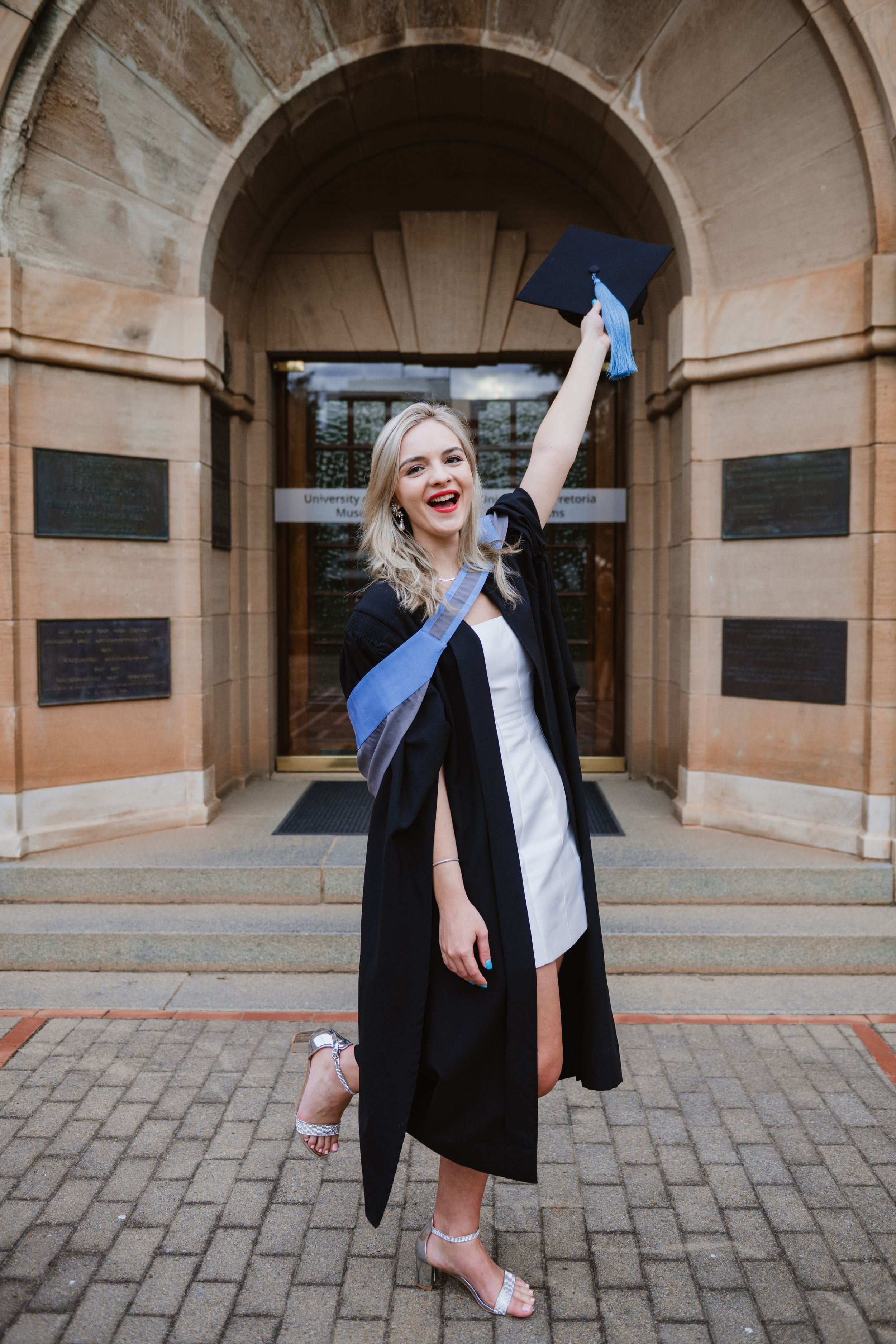 University of Pretoria graduate posing outdoors in her graduation gown and cap.