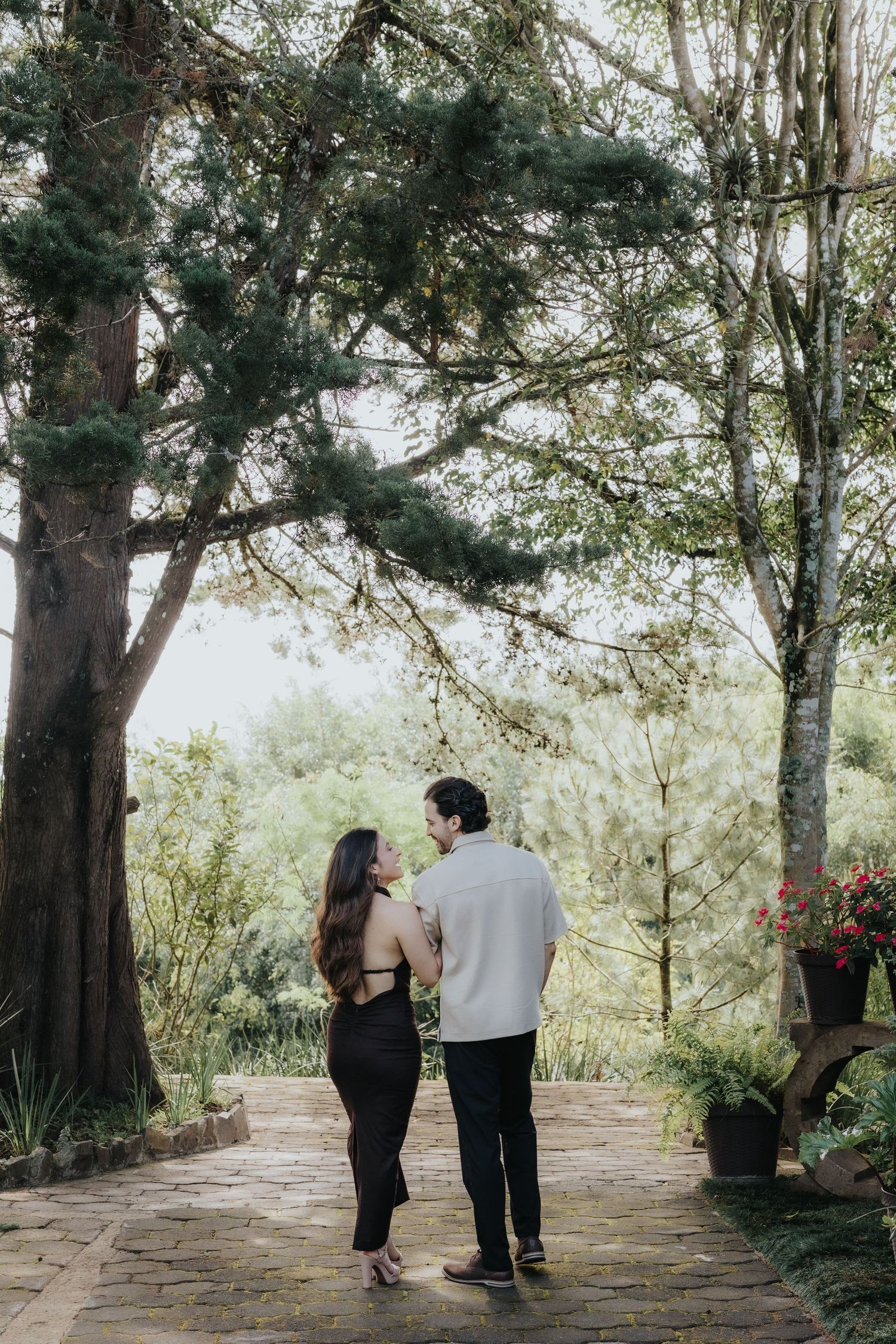 Pareja de pie en sendero rodeado de árboles en Save the Date / Couple standing in tree-lined path for Save the Date.