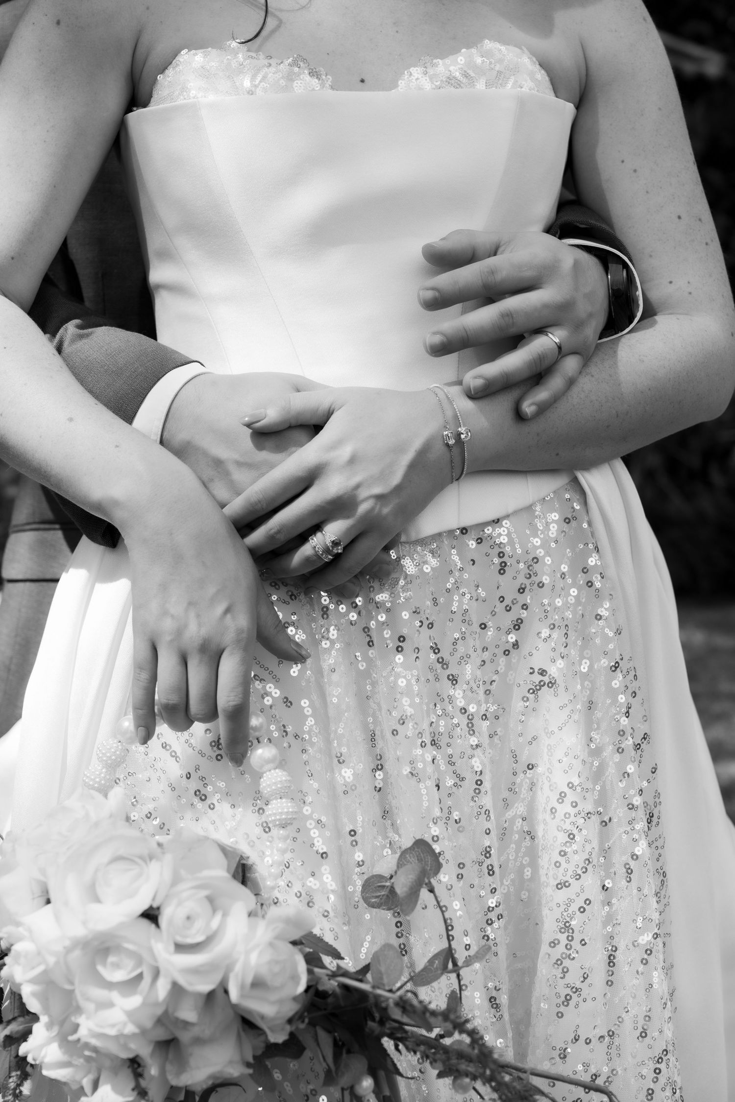 Primer plano en blanco y negro de novios abrazados mostrando detalle estilo moderno / Black and white close-up of bride and groom