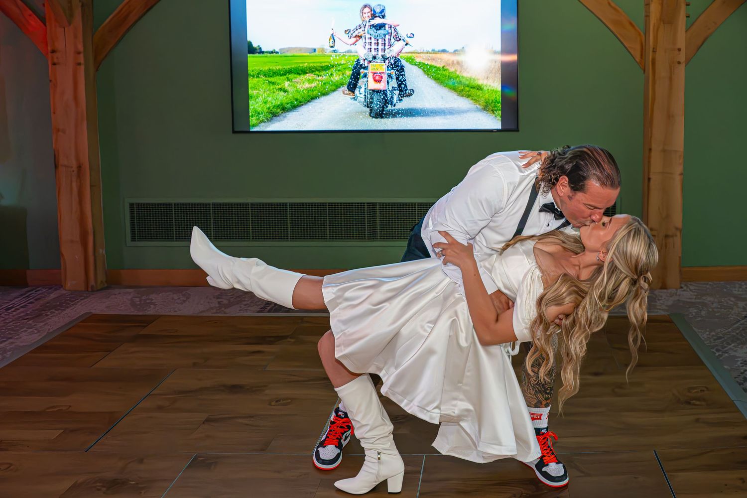Couple sharing a romantic dip kiss in wedding attire, bride in white dress and sneakers, groom in white shirt, First dance.Yorkshire, Leeds