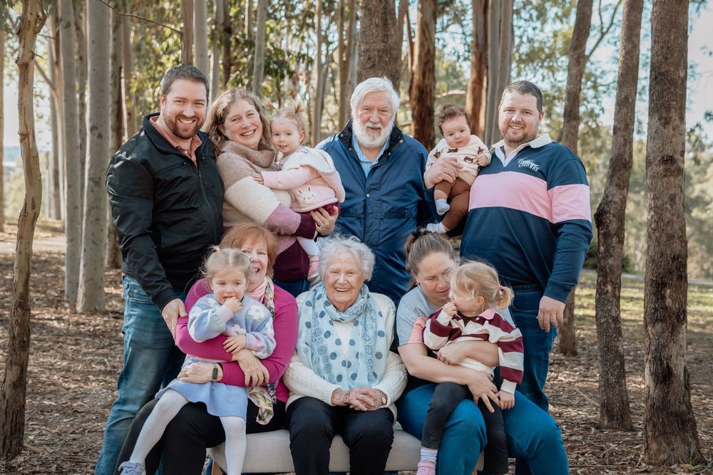 Multi-generational family portrait outdoors at Rouse Hill Regional Park, featuring grandparents, parents, and children smiling together.