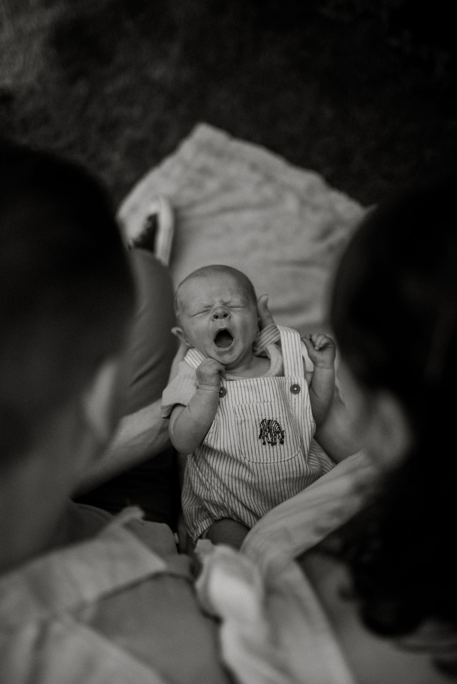Black and white portrait of a sleeping baby in striped clothing.