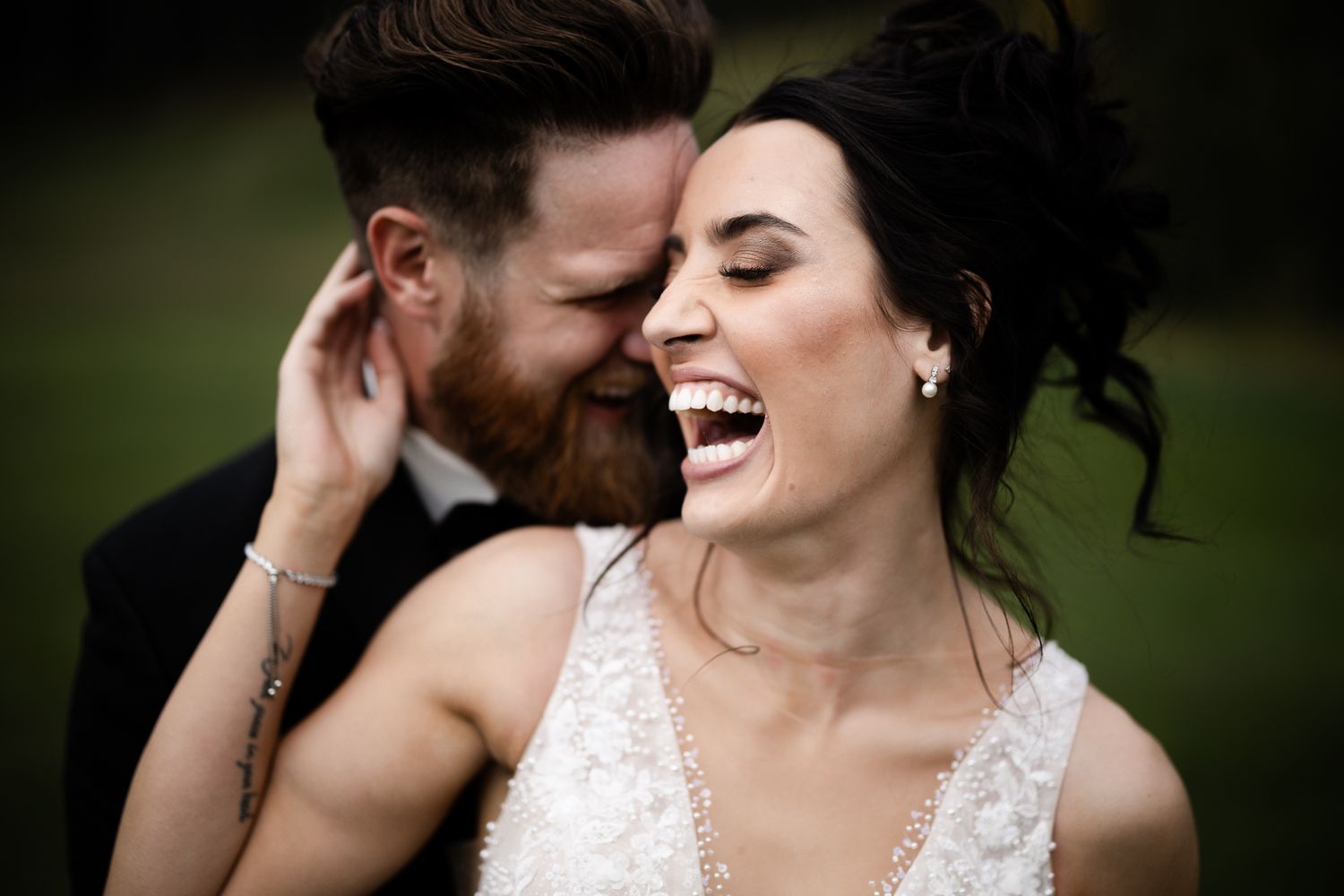 Bride and groom laughing candidly during wedding portraits