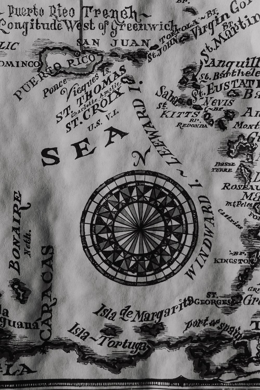 Vintage black and white antique map of the Caribbean Sea featuring a decorative compass rose and island names.