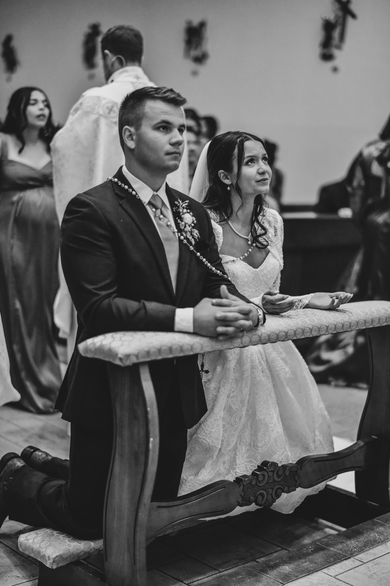 Bride and groom kneeling during Eucharistic Prayer at Catholic wedding Mass