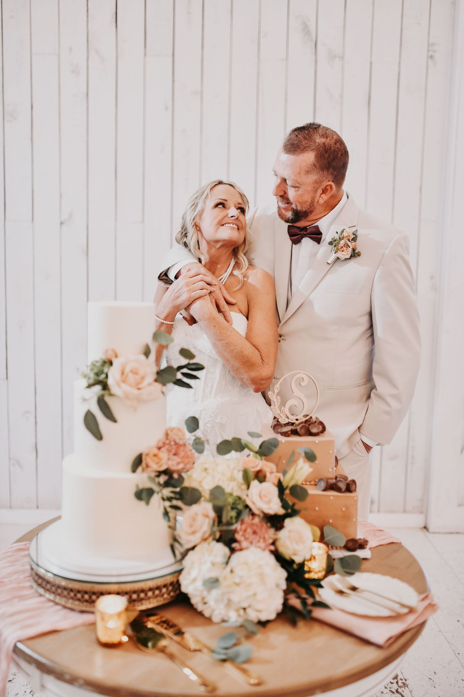 Classic white wedding cake decorated with soft pink and ivory flowers