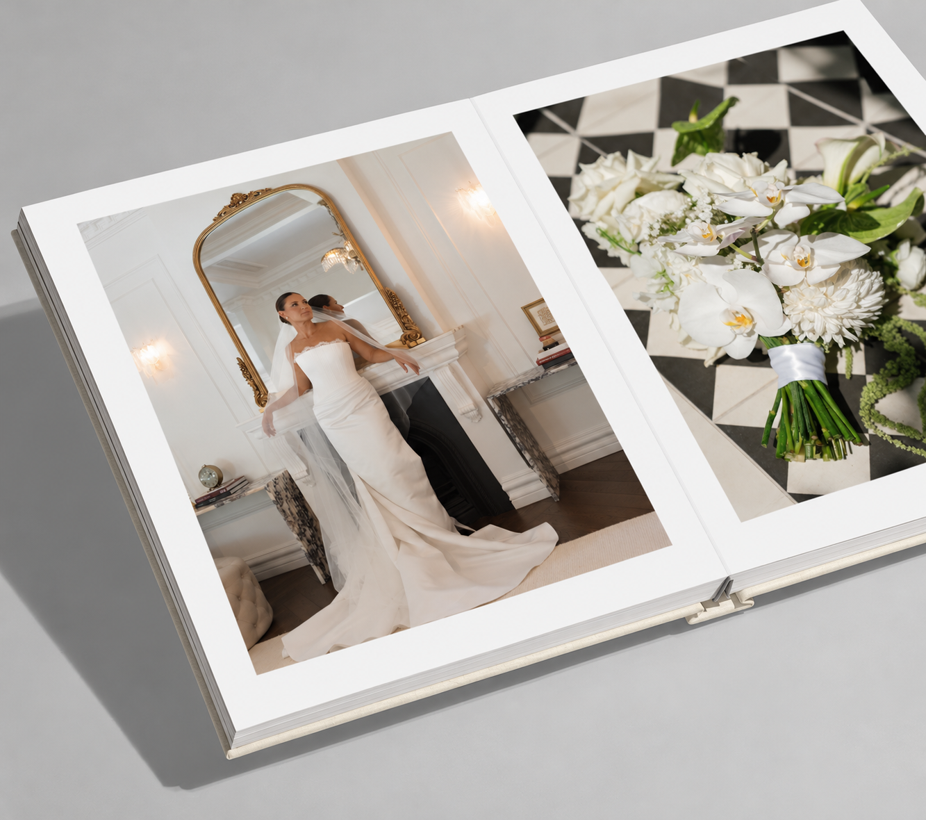 Black and white wedding photo album titled OUR DAY showing a bride in a flowing gown and veil with her groom, resting on a stack of books.