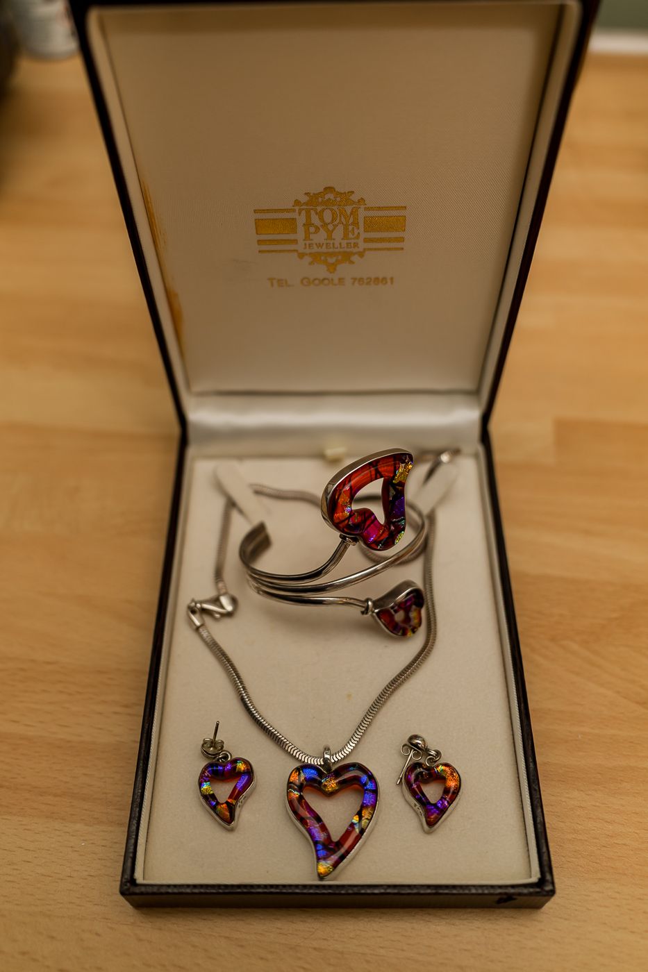 Silver heart jewelry set with colorful mosaic inlay, including necklace, bracelet, and earrings displayed in a gift box.