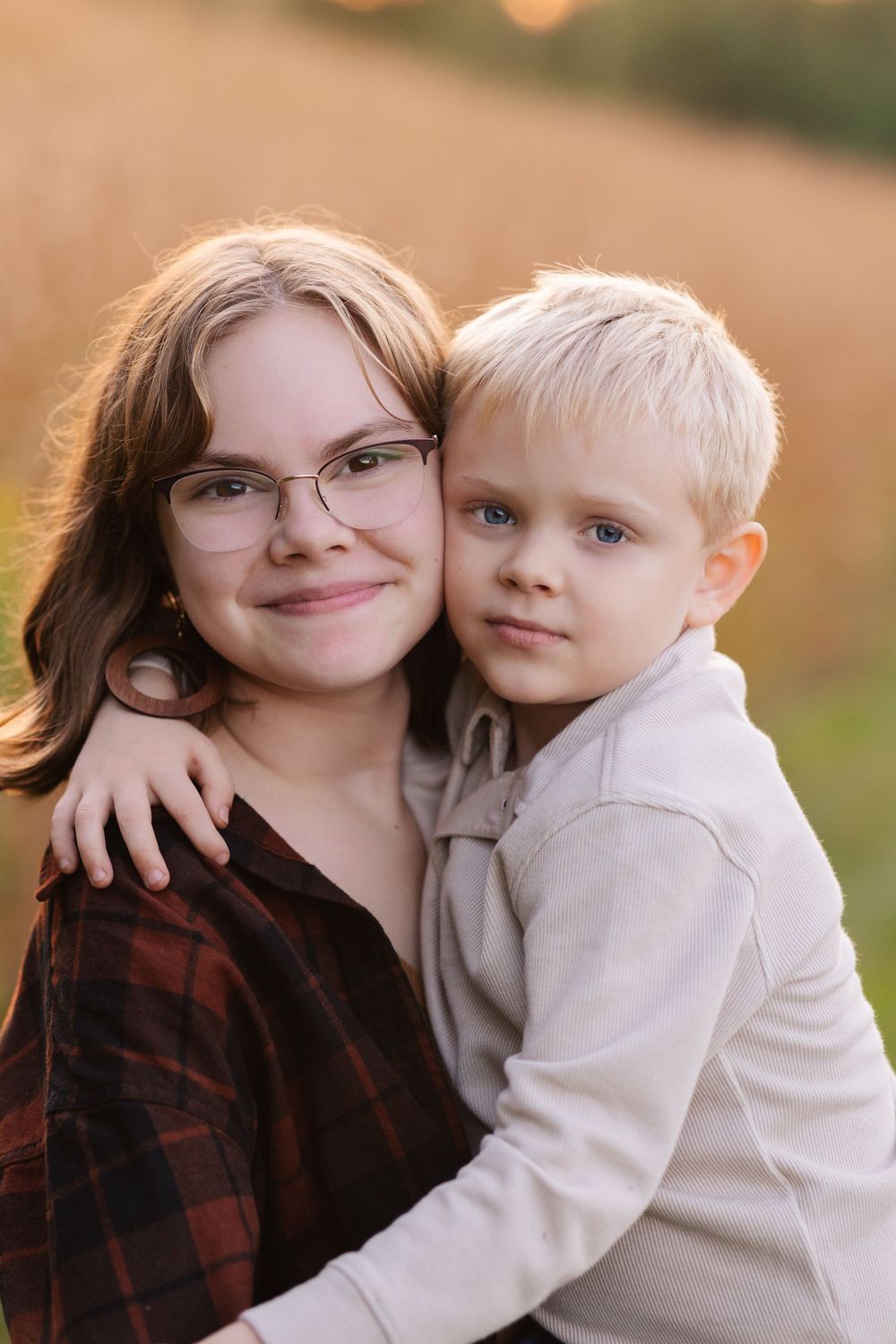 Close-up portrait of a teen and young child in autumn light with warm tones and natural expressions. Twin Cities, Decorah Iowa wedding photo