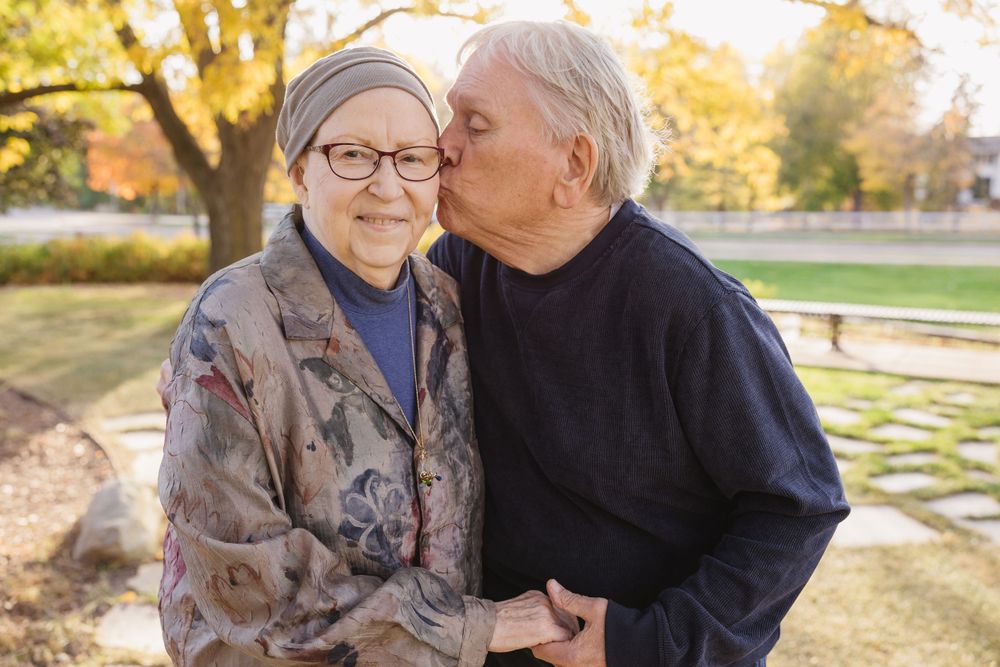Senior couple sharing tender moments in a park during golden hour. Twin Cities, Decorah Iowa wedding photography