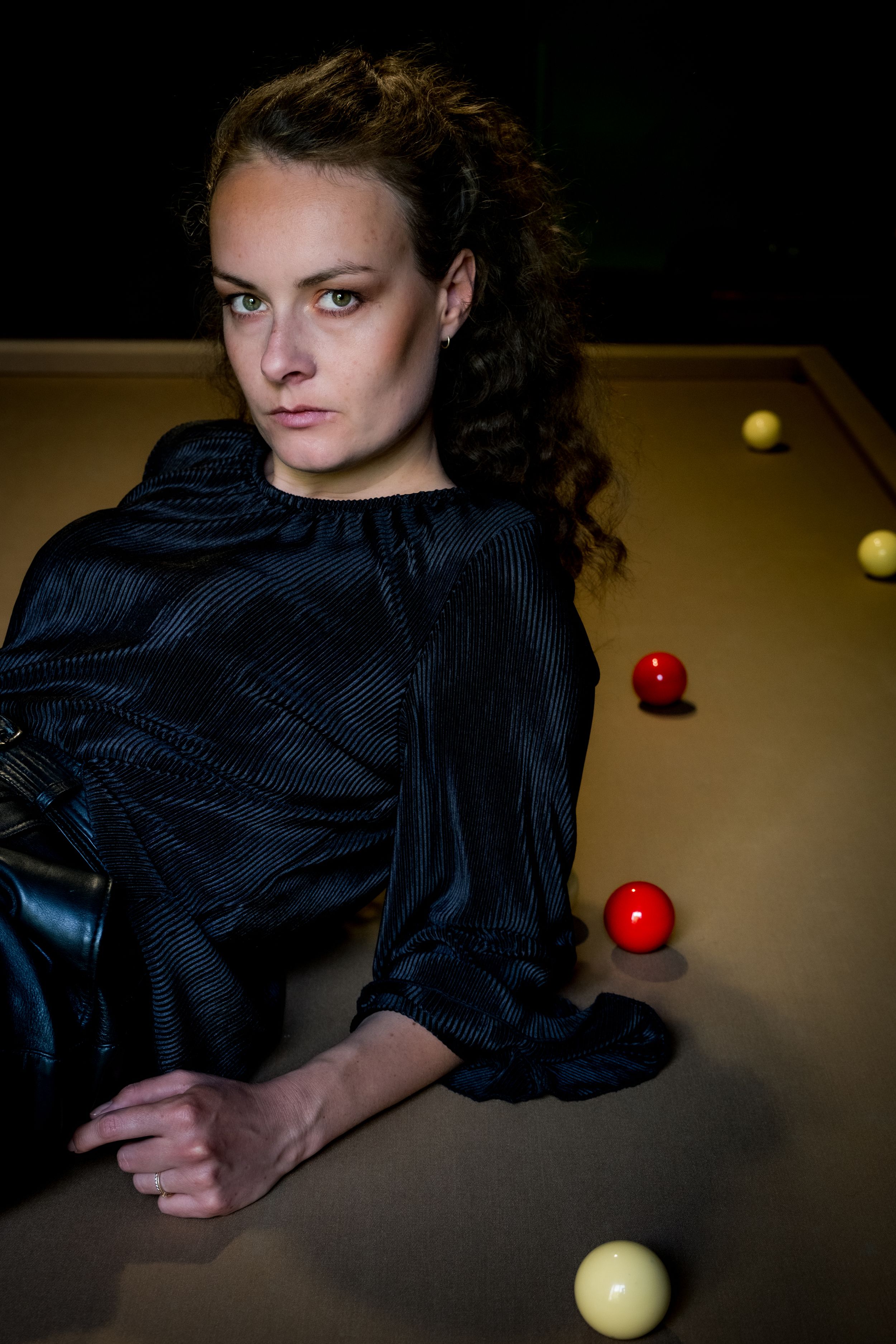 Portrait éditorial réalisé autour d'une table de billard dans un intérieur élégant.