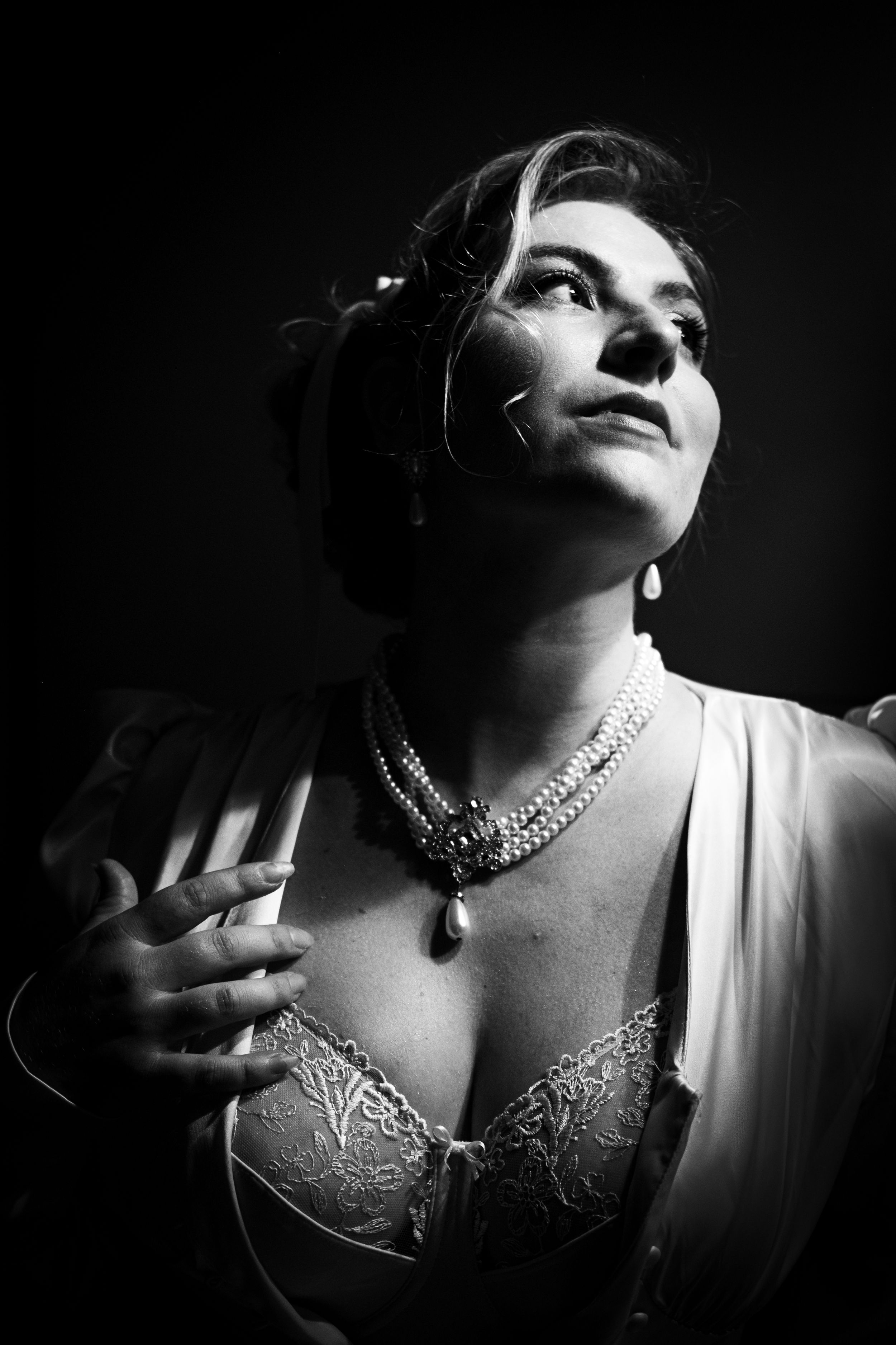 Portrait féminin en noir et blanc réalisé en clair-obscur dans une ambiance élégante.