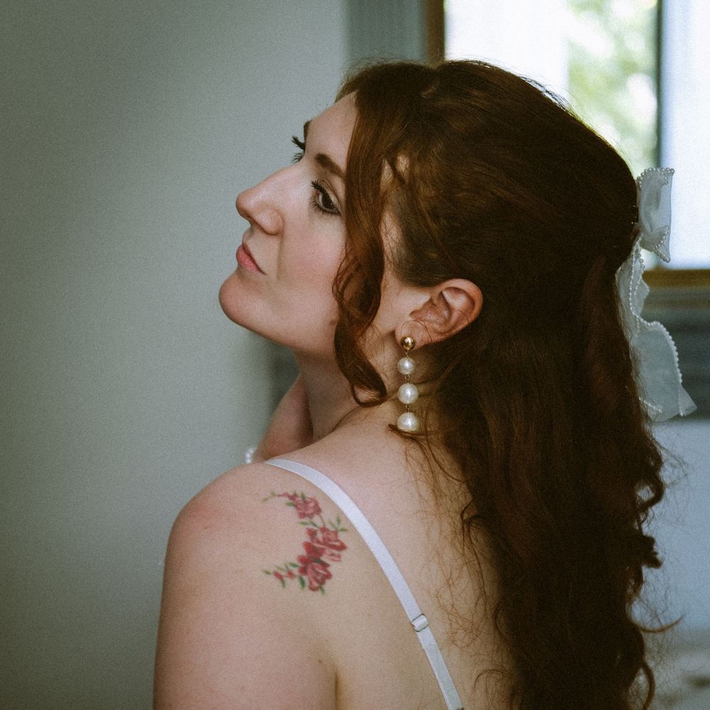 Portrait de profil d’une femme près d’une fenêtre, éclairée par une douce lumière naturelle.