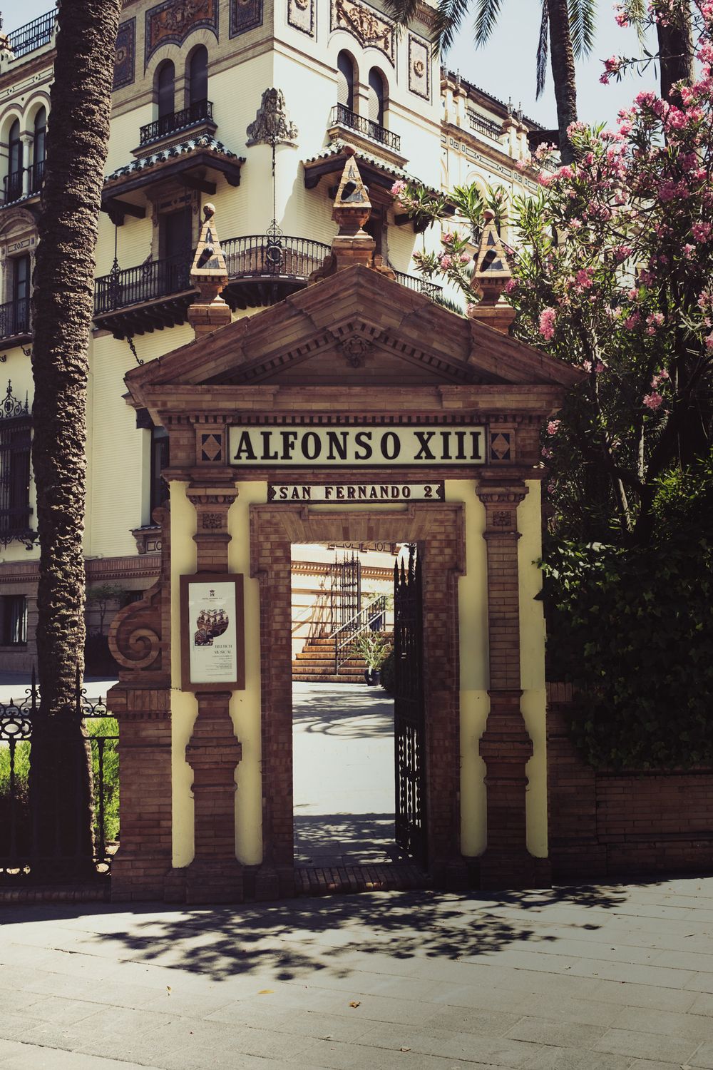 Historic Alfonso XIII hotel entrance gate on San Fernando street in Seville, Spain.