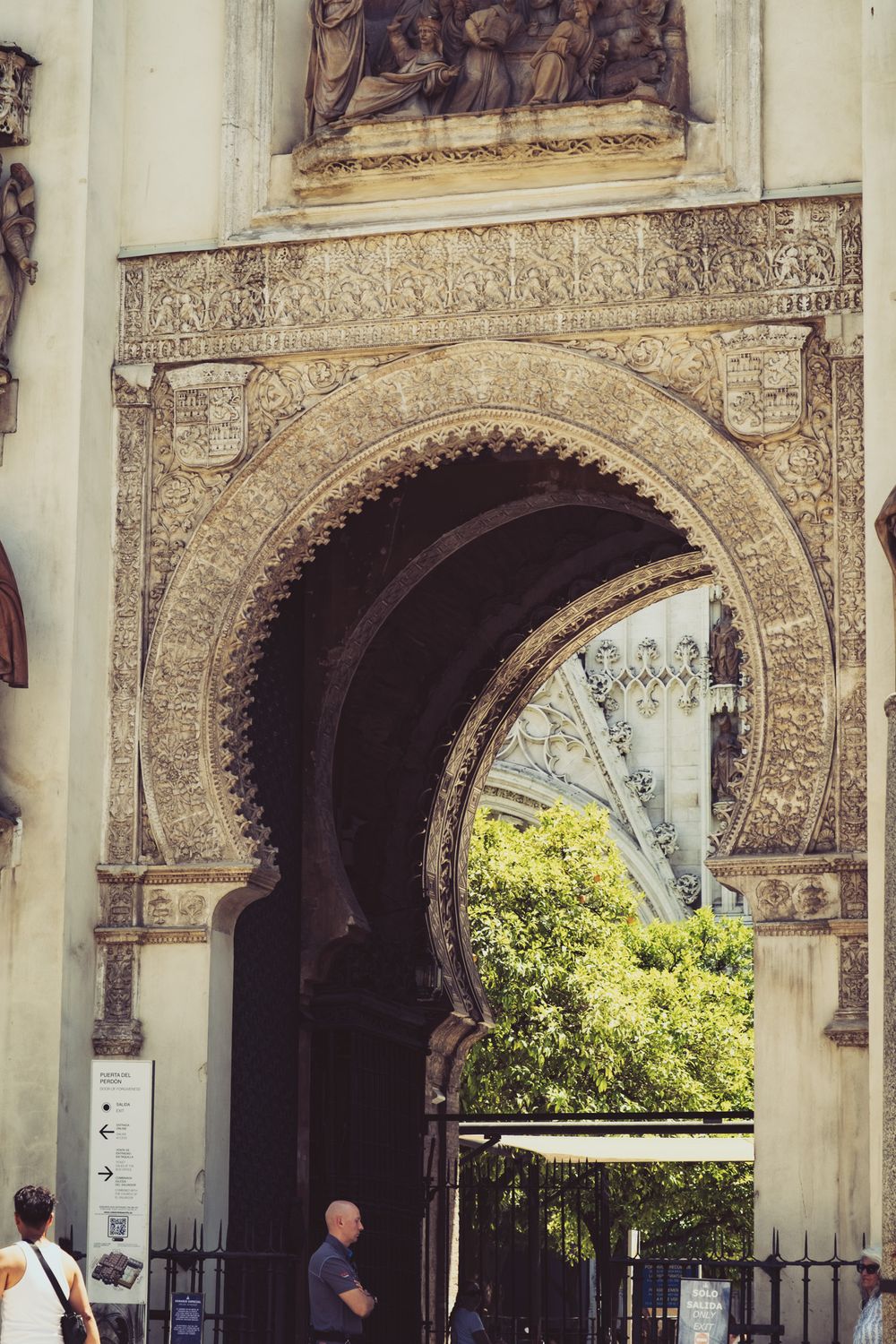 Ornate Moorish horseshoe arch entrance gate of Seville Cathedral with intricate carvings, Spain.