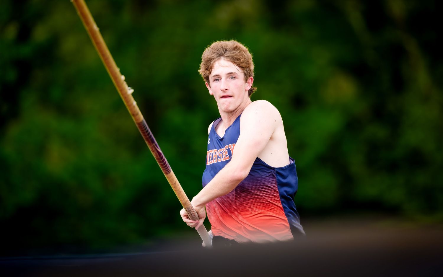 Hershey Trojans athlete running up to pole vault vs. Cedar Cliff, by Deanna Fox, SportsFox Photography, Hershey PA
