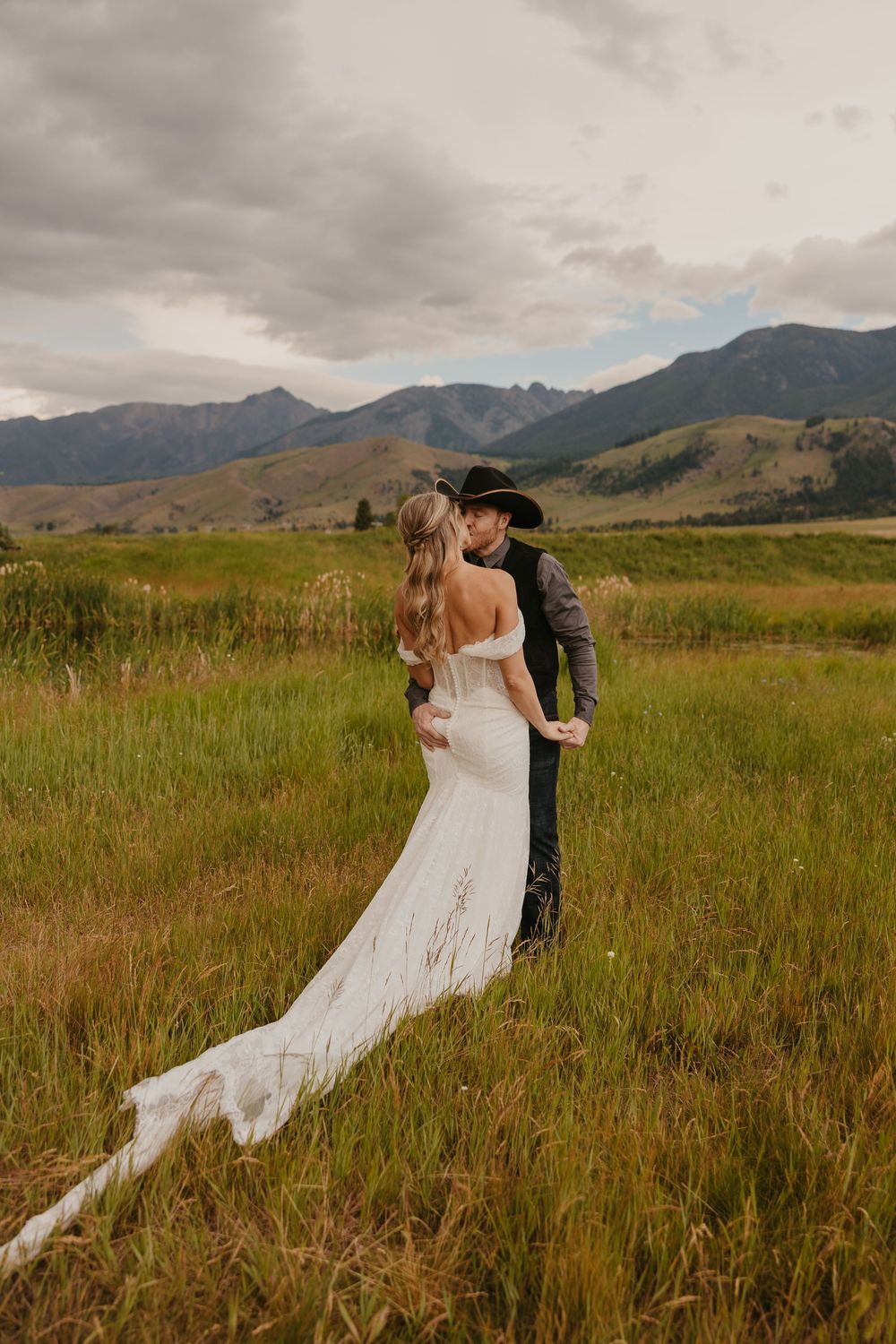 Bride and groom embrace under the mountains in Emigrant, Montana captured by local Paradise Valley Wedding Photographer near Yellowstone