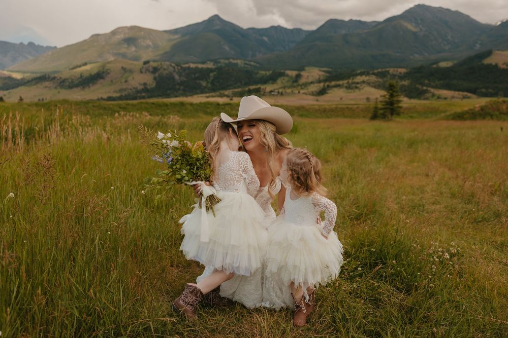 Flower girls run to bride on her wedding day at Copper Rose Ranch in Paradise Valley near Yellowstone captured by Local Wedding Photographer
