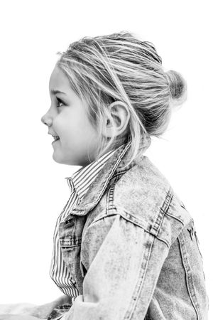 Black and white side profile portrait of a young girl with a bun hairstyle wearing a denim jacket.