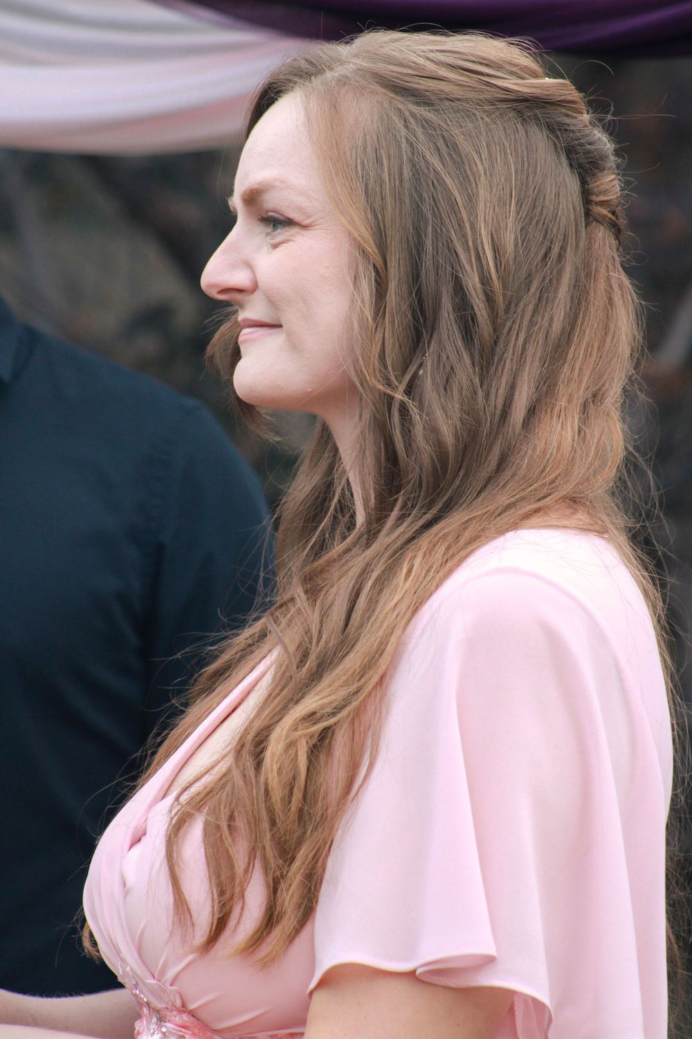 A person with long brown hair wearing a light pink top is shown in a series of profile views.