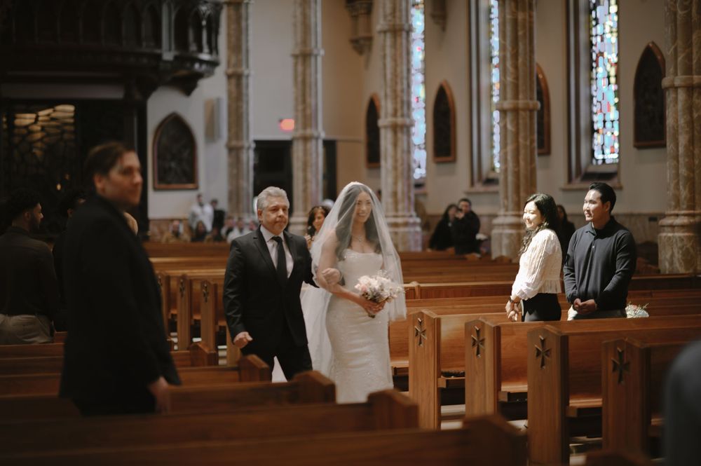 Bride walking down the aisle with her father in a beautiful church wedding ceremony.