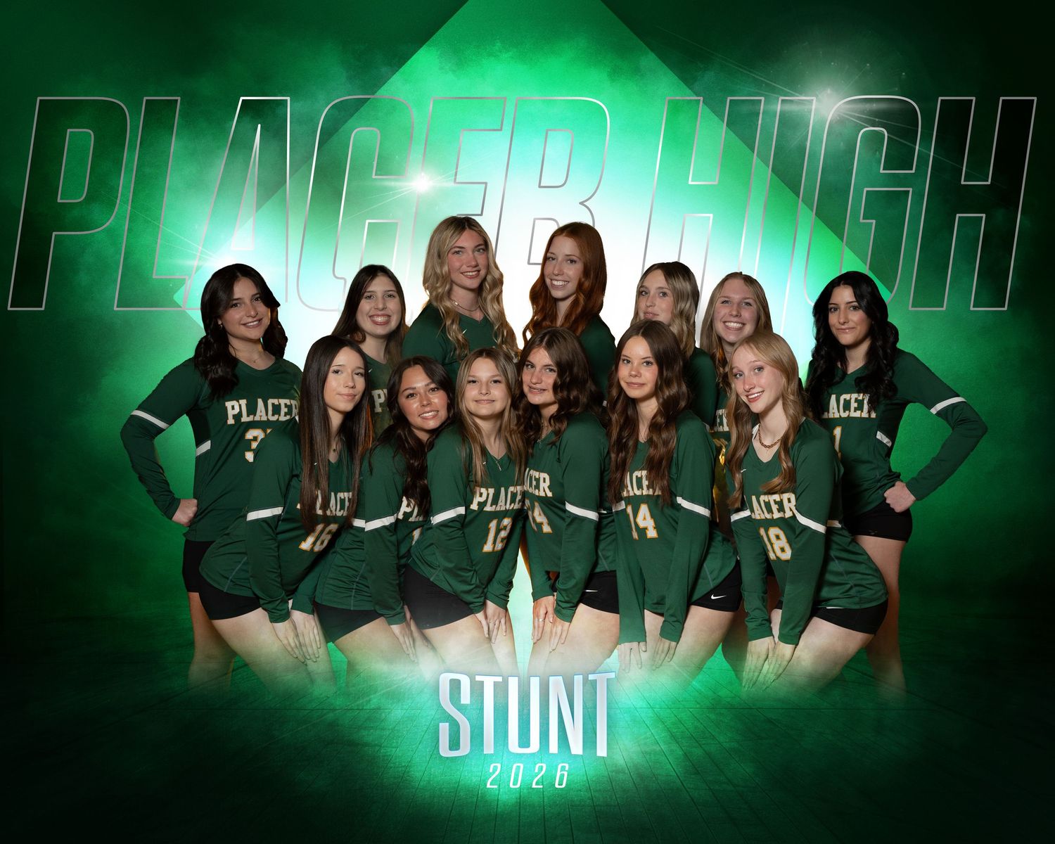 A cheerleading squad in green and white uniforms poses together on a football field.