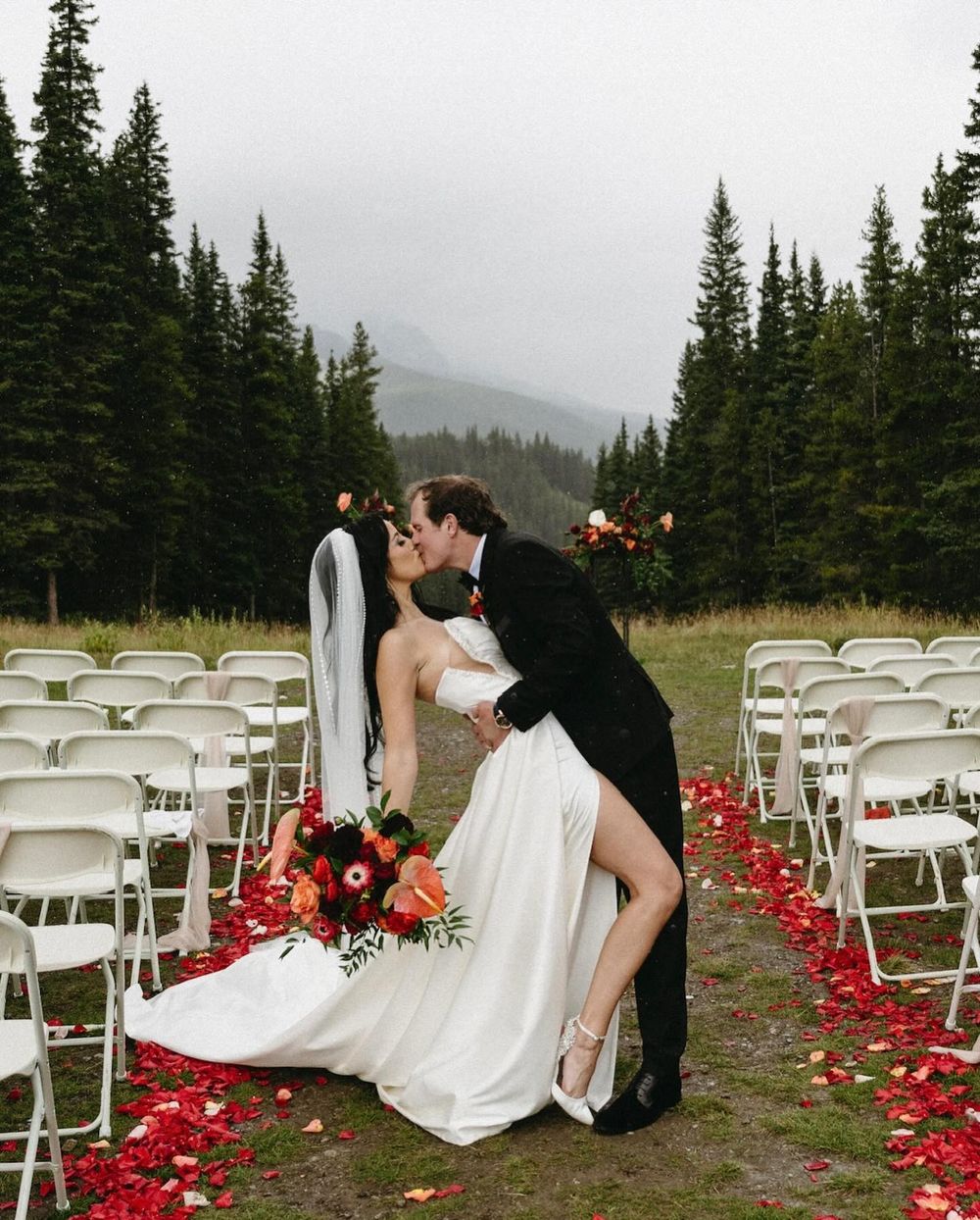 Sarah and Lee kissing on a petal aisle at their Mount Norquay ceremony