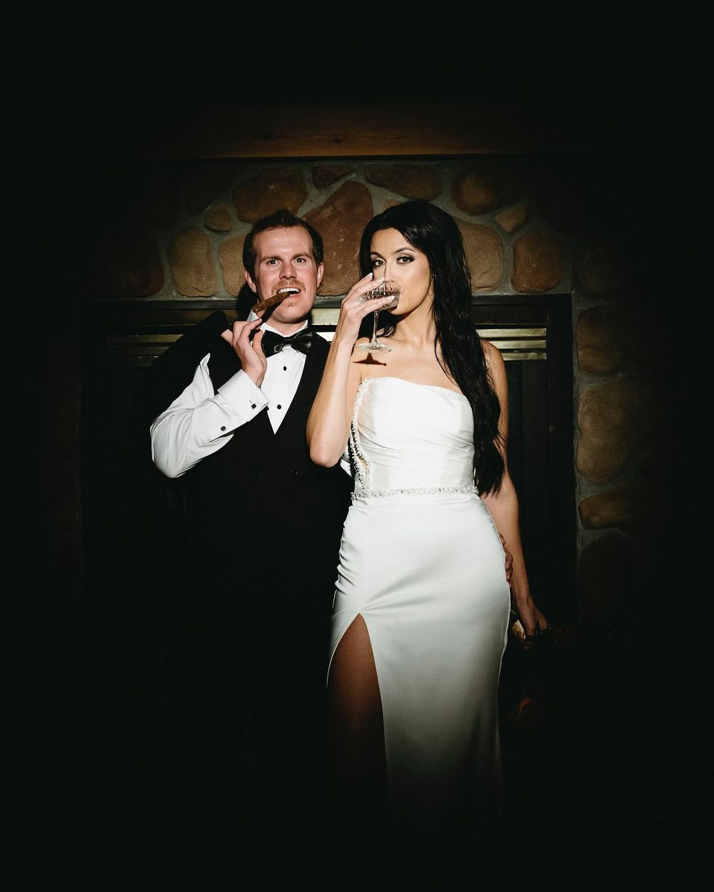 Sarah and Lee by the fireplace with drinks at Mount Norquay lodge in Banff