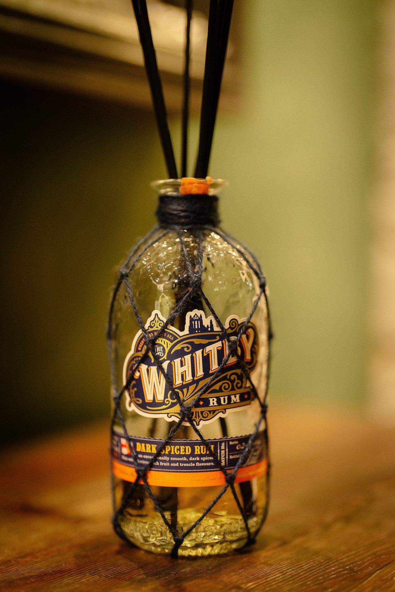Reed diffuser in a Whitby rum bottle scenting the wedding venue