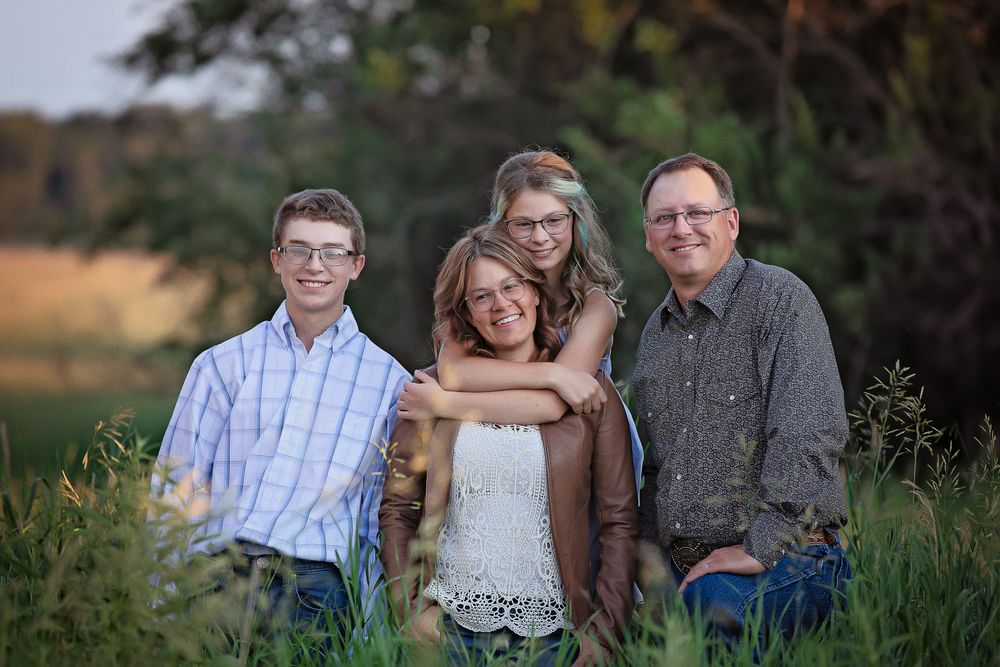 family of 4 in the tall green grass