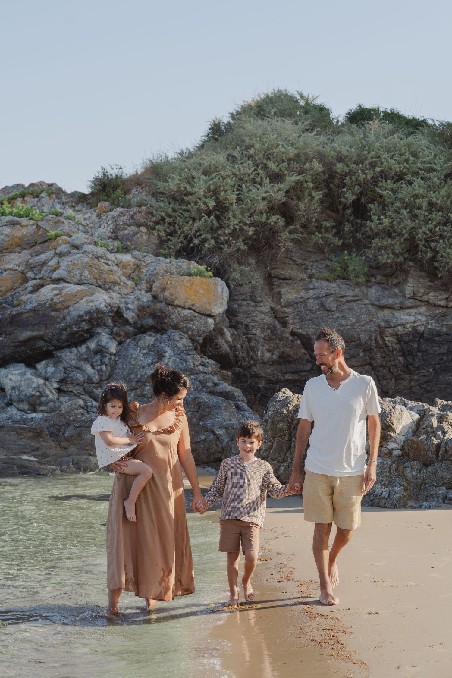 Famille marchant main dans la main sur la plage