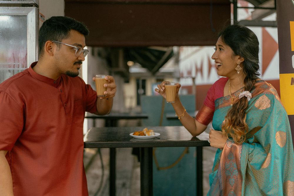 Indian couple in traditional attire enjoying drinks and snacks at Madras Coffee House cafe.