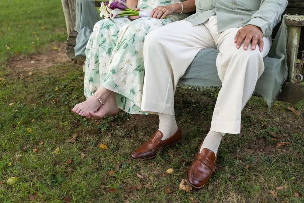 Karen and George sitting together on a swing by the river at their bed and breakfast wedding in the Shenandoah Valley
